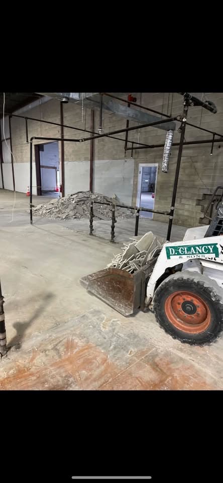 Clancy skid steer clearing debris on an interior demolition job